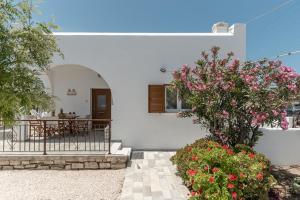 a white house with a table and flowers at Villa Grevillea Mikri Vigla in Mikri Vigla