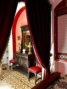 Zimmer mit einer Kommode und einem roten Vorhang in der Unterkunft Dar Aziz in Sousse