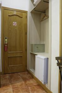 a hallway with a wooden door and a refrigerator at Hostal Las Fuentes in Madrid