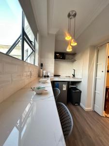 une cuisine avec un comptoir blanc et une table dans l'établissement Spacube Luxury Suites and Spa, à Pretoria