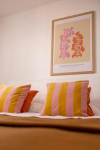 a bed with two pillows and a picture on the wall at Bungalows El Arenal in Jávea
