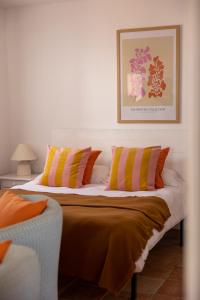 a bedroom with a bed with orange and yellow pillows at Bungalows El Arenal in Jávea