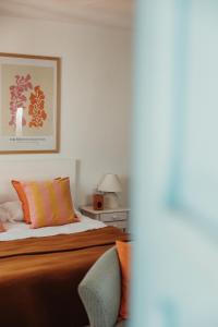 a bedroom with a bed with an orange blanket at Bungalows El Arenal in Jávea