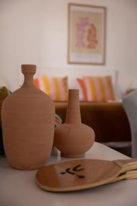 two vases sitting on a table next to a cutting board at Bungalows El Arenal in Jávea