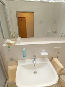 a bathroom with a white sink and a mirror at Hotel Garni Stadt Friedberg in Friedberg