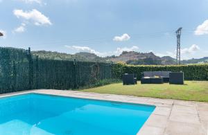 a swimming pool in a backyard with a table and chairs at Fidalsa Majestic in Puente Arce