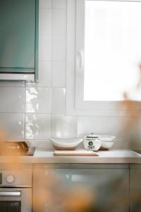 una cocina con armarios blancos y cuencos en una encimera en Los Bungalows Del Arenal, en Jávea