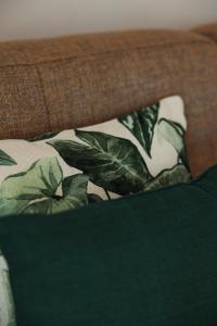 a bed with a green and white blanket and a pillow at Los Bungalows Del Arenal in Jávea