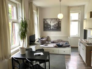 a living room with a bed with a person sleeping on it at Ferienwohnungen und Apartmenthaus Halle Saale - Villa Mathilda in Halle an der Saale