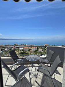 balcone con sedie, tavolo e vista sull'oceano di Apartments Blaža a Podstrana