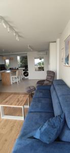 a living room with three blue couches and a kitchen at AriaSpot Alicante in Gran Alacant +11 photos