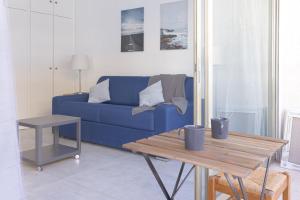 ein blaues Sofa im Wohnzimmer mit einem Tisch in der Unterkunft GuestReady - Cannes Delight near Mouré Rouge Port in Cannes
