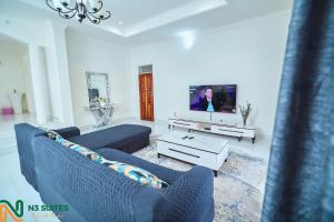 a living room with two blue couches and a tv at The N3 Luxury Suite in Mzuzu