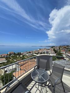 balcone con tavolo, sedie e vista sull'oceano di Apartments Blaža a Podstrana