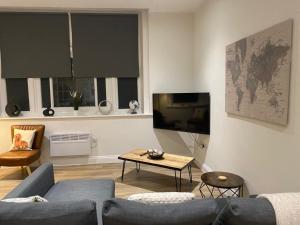 Flat 2 ,559 Wimborne Road في بورنموث: غرفة معيشة مع أريكة وتلفزيون وطاولة