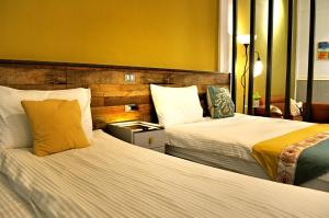 two beds in a hotel room with two beds at Lu-Kang Traveler Inns in Lukang