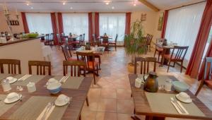 a restaurant with wooden tables and chairs and windows at Hotel Garni Stadt Friedberg in Friedberg
