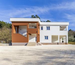 a contemporary house with white and orange at Holiday House emjalemi in Pula