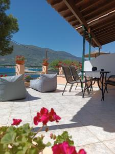 a patio with a table and chairs and flowers at Ilios studios in Vasiliki