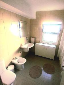 ポンタ・デルガダにあるApartamento Coutoのバスルーム(洗面台、トイレ付)、窓が備わります。