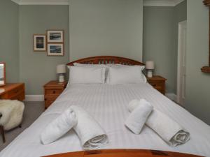 a bedroom with a bed with towels on it at Five Bells Cottage in Alnmouth