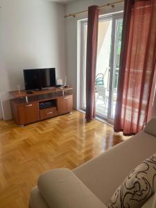 Il comprend un salon doté d'un canapé et d'une télévision à écran plat. dans l'établissement Apartment Toni, à Makarska