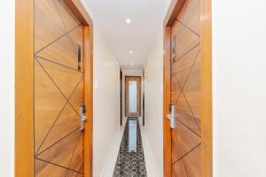 a hallway with wooden doors and a tile floor at FabHotel Airport Palace in Mumbai