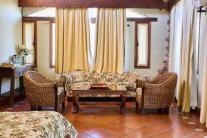 un soggiorno con divano, sedie e tavolo di La Casa De La Bodega - Wine Boutique Hotel a Cafayate