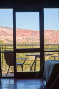 a room with a view of the desert through a window at La Casa De La Bodega - Wine Boutique Hotel in Cafayate