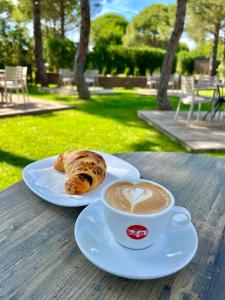 a cup of coffee and a pastry on a table at Apart Hotel Perla Resort Lalez Durres in Durrës