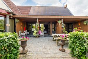 a house with a solar roof and a patio at Tumuli Twente B&B Boutique Hotel in Nutter