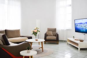 a living room with couches and tables and a tv at Ixia Manor House in Ixia