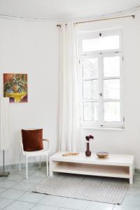 a white living room with a table and a window at Ixia Manor House in Ixia