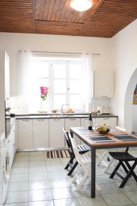 a kitchen with white cabinets and a wooden ceiling at Ixia Manor House in Ixia