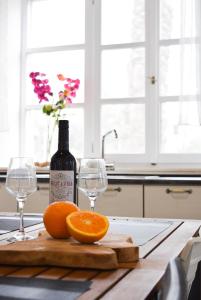 a bottle of wine and two oranges on a cutting board at Ixia Manor House in Ixia