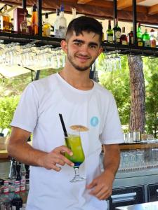 un hombre sosteniendo un trago en un vaso de martini en Apart Hotel Perla Resort Lalez Durres en Durrës