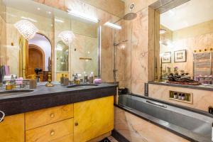 a bathroom with a sink and a large mirror at GuestReady - Séjour de Charme à Neuilly in Neuilly-sur-Seine