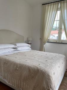 - un lit blanc dans une chambre avec fenêtre dans l'établissement Residenza Il Campanile, à Sorrente