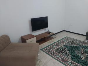 a living room with a couch and a flat screen tv at L'escale in Tunis