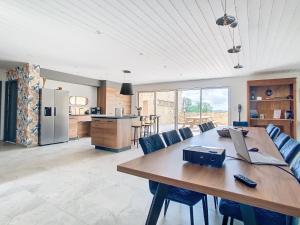 een keuken en eetkamer met een grote houten tafel bij Au Vent des Collines in Les Épesses
