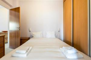 een slaapkamer met een groot wit bed met 2 kussens bij GuestReady - Enchanting Retreat in Paço de Arcos in Paço de Arcos