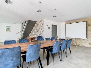 een eetkamer met een houten tafel en blauwe stoelen bij Au Vent des Collines in Les Épesses +25 foto's