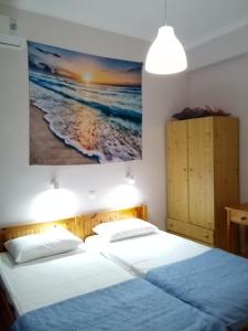 two beds in a room with a painting on the wall at Studios Thomas in Limenaria