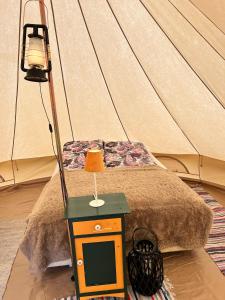 里瑟尔Hommen Gård Glamping的帐篷里有一张小桌子，上面有一盏灯