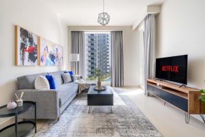 a living room with a couch and a tv at GuestReady - A prime stay in Creek Harbour in Dubai