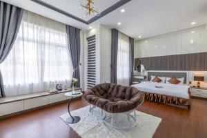 a bedroom with a bed and a chair in a room at Teky House Huế in Thôn Trường Giang
