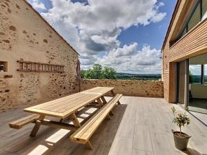 een houten picknicktafel op een patio bij Au Vent des Collines in Les Épesses