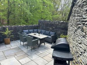 a patio with a table and chairs and a grill at Spacious Property with Waterfall View by LetMeStay in Ambleside +18 photos