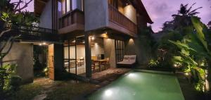 een huis met een zwembad ervoor bij Purana Boutique Resort in Ubud