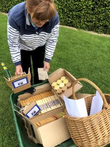 a woman standing next to a table with boxes and baskets at Whittlewood Shepherd's Hut in Silverstone, Cosy, Rural, Views in Silverstone +26 photos